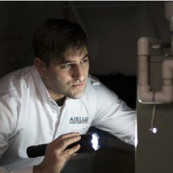 an HVAC technician inspects a furnace